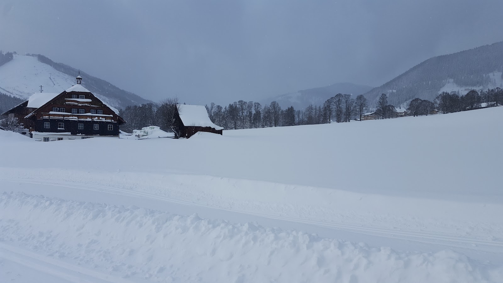 The Dachstein massif towering over snow covered Ramsau farmhouses