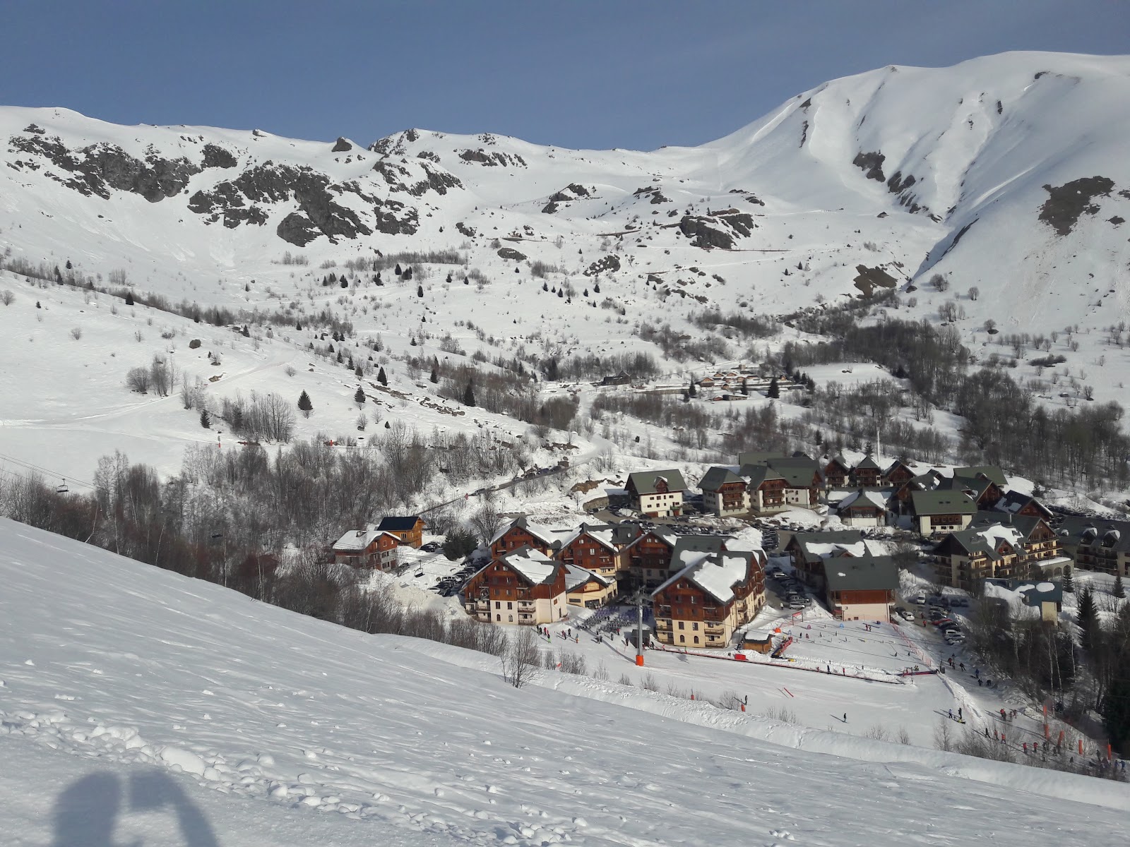 The traditional village of Saint Sorlin d Arves beneath sunny ski slopes