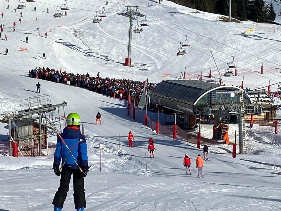 Skiers on a sunny groomed run in the Grand Massif