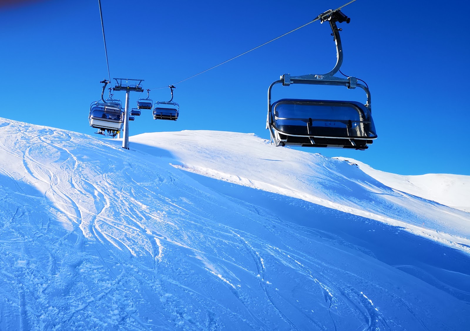 Gondola climbing toward Vallalpe above the snowy valley