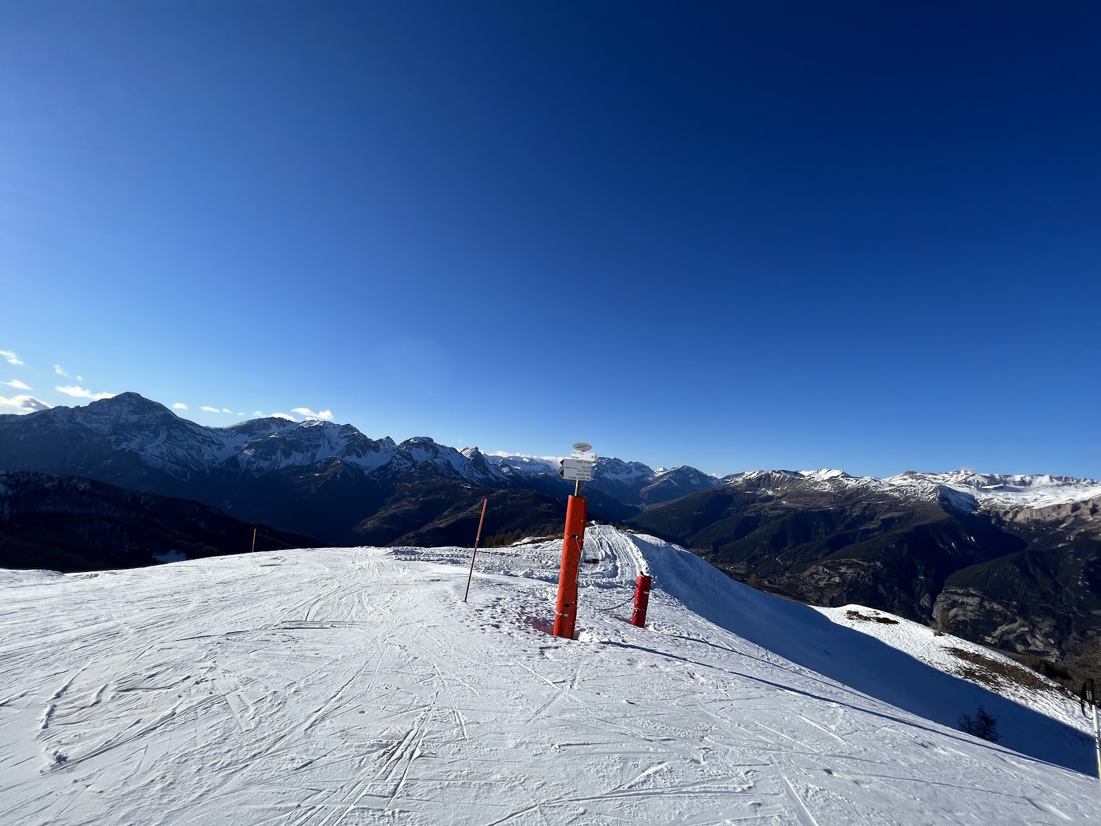 A sunny tree lined red piste above Sauze d Oulx