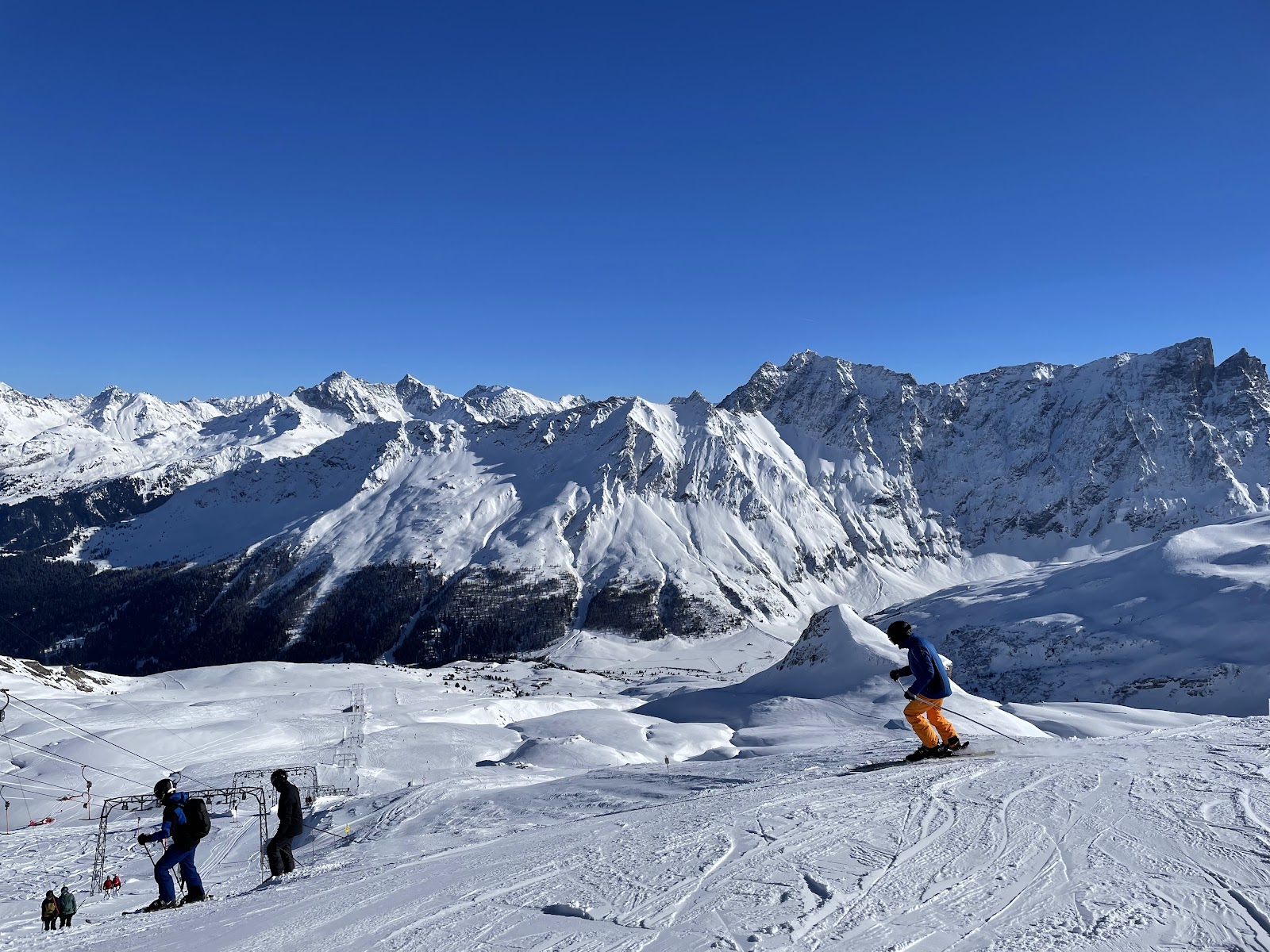 Skiers cruising the sunny Savognin slopes