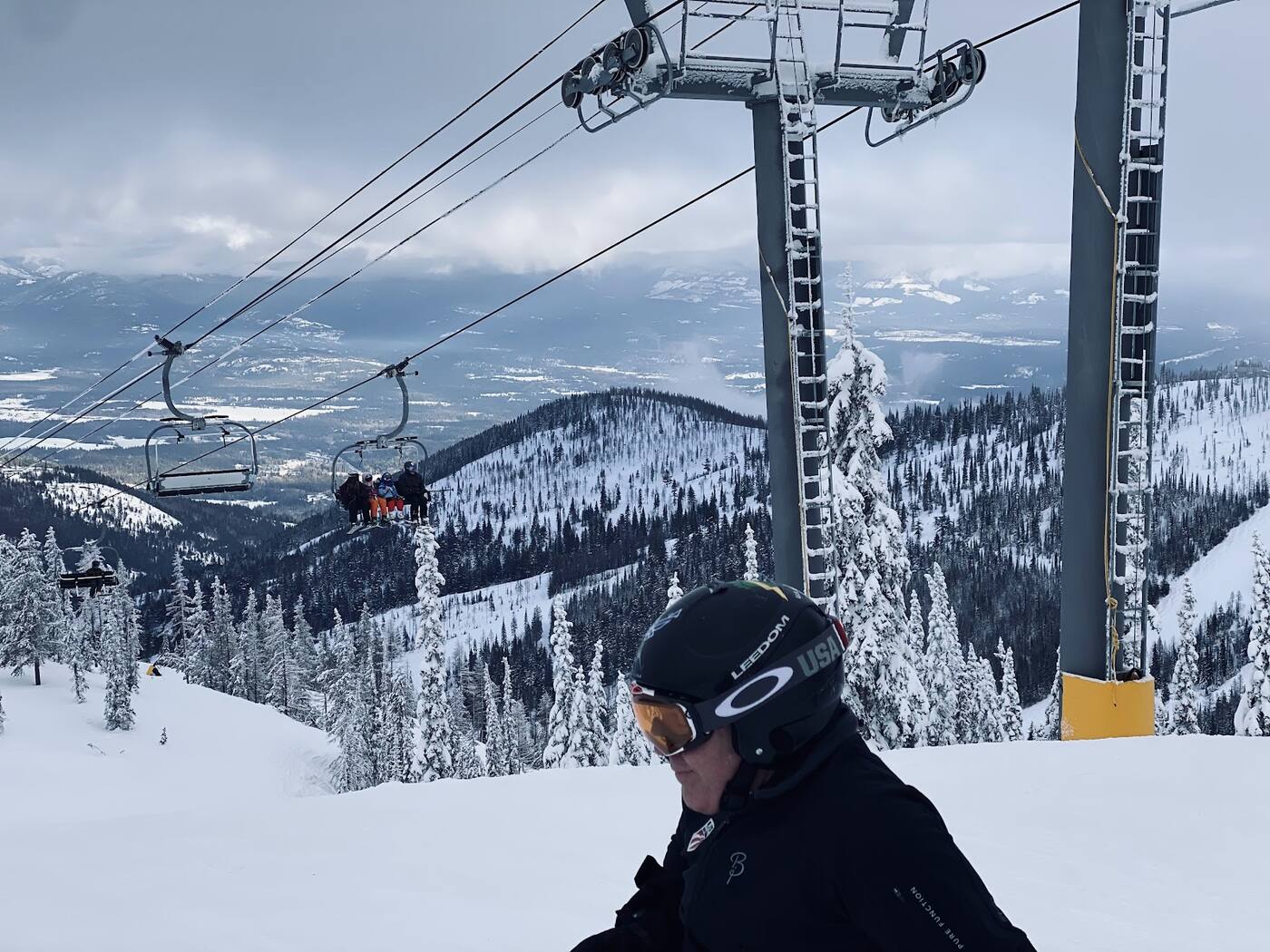 A skier on an uncrowded groomed run through trees at Schweitzer