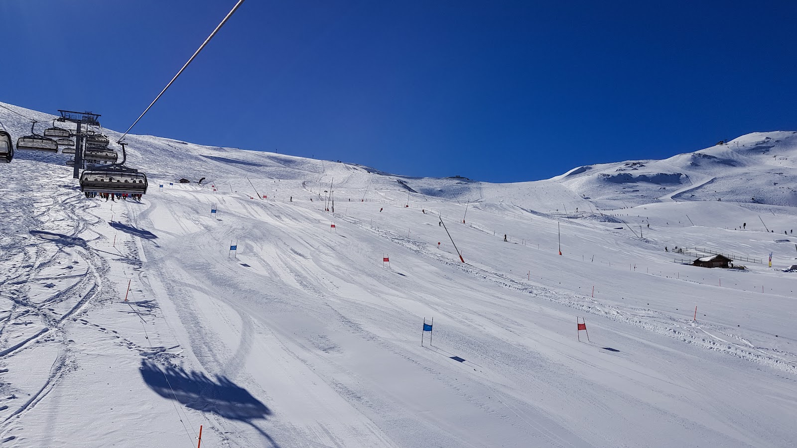 A modern chairlift carrying skiers over a high snowy slope