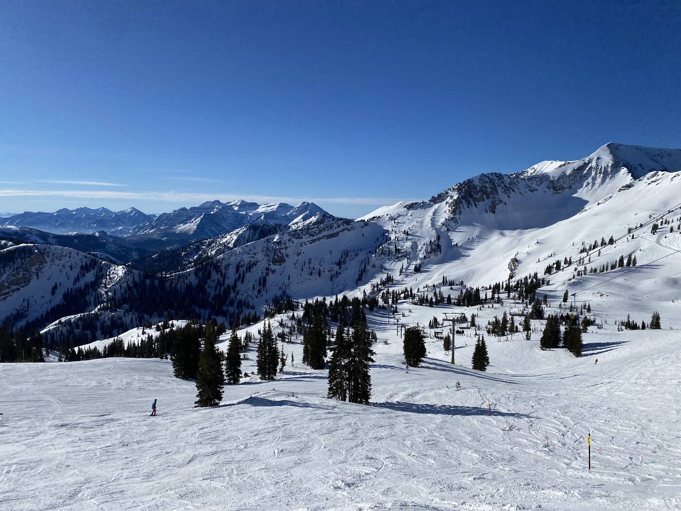 Skiers below Hidden Peak at Snowbird under deep powder