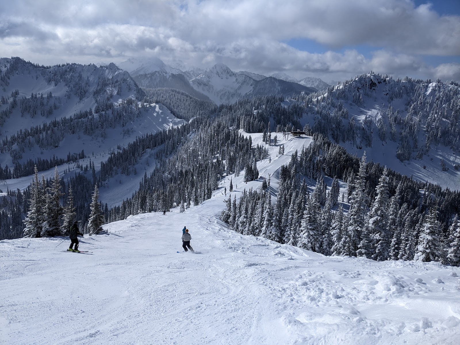 Chairlift rising through snow covered Cascade trees in low cloud