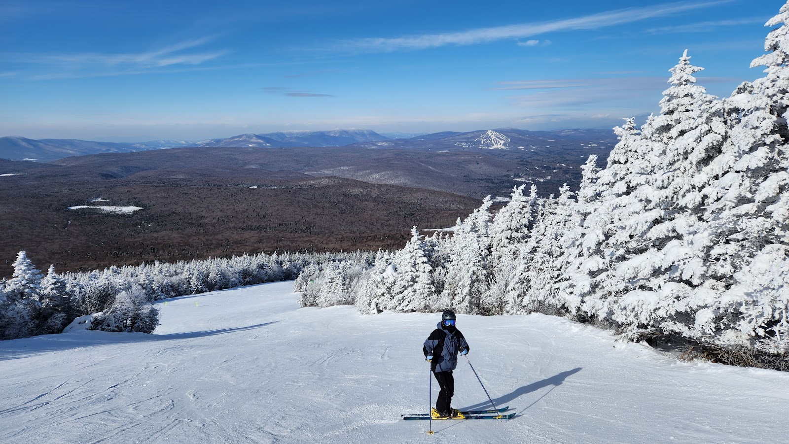 A chairlift rising over snowy wooded slopes at Stratton