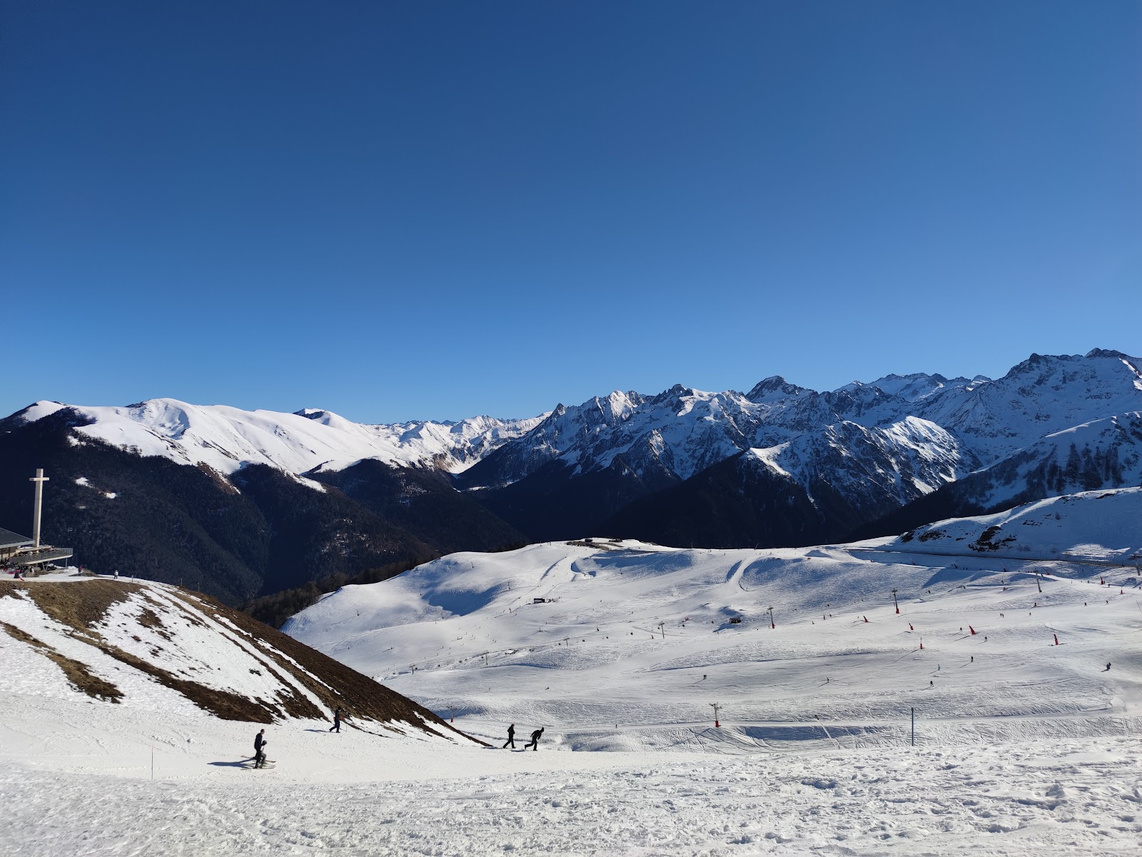 The grand old hotel building and sunny pistes at Superbagneres