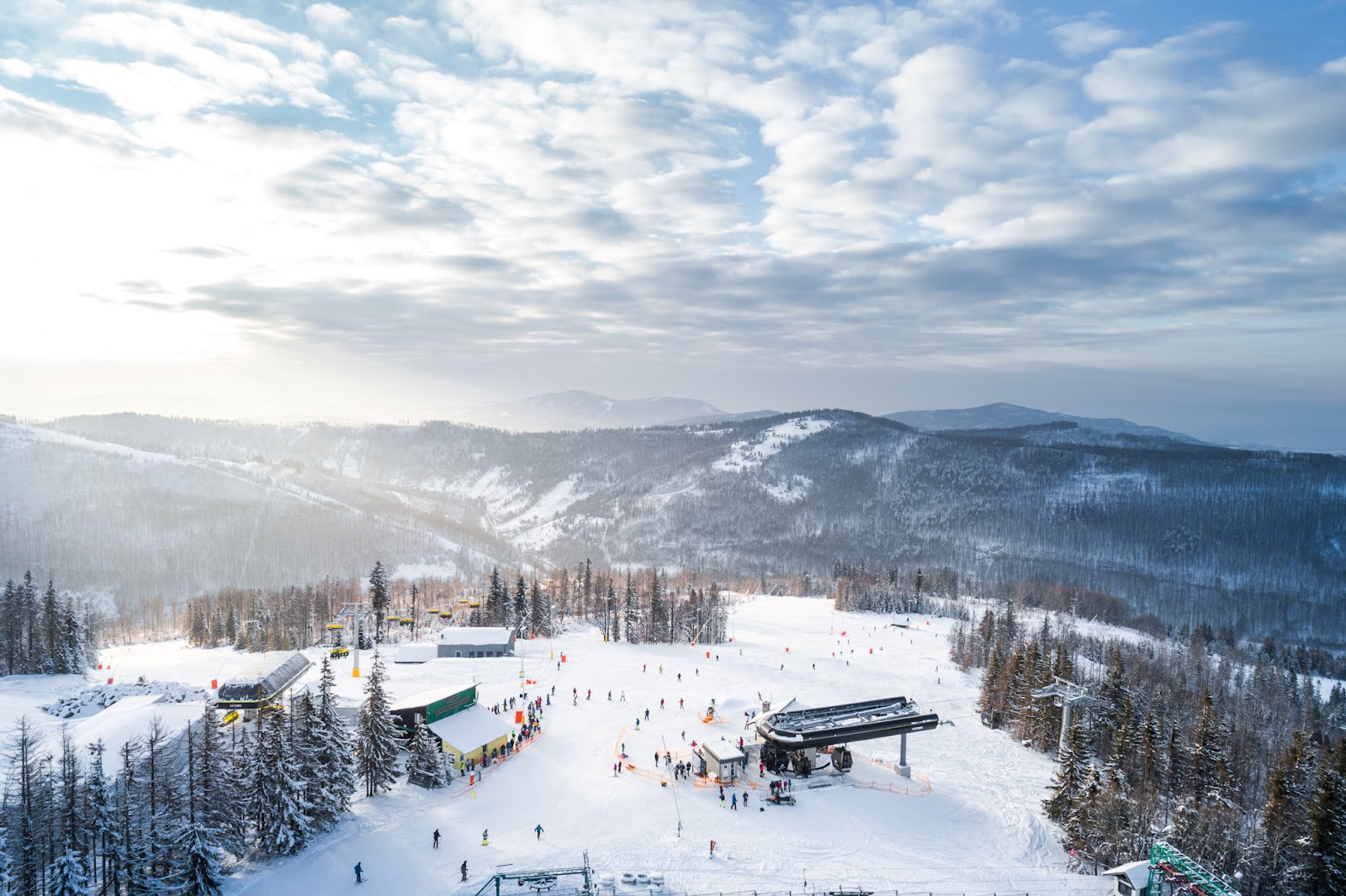 Wide groomed intermediate pistes through forest at Szczyrk in the Polish Beskids