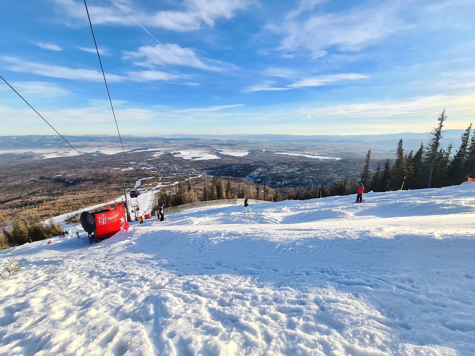 Skiers on a snowy intermediate run at Tatranska Lomnica