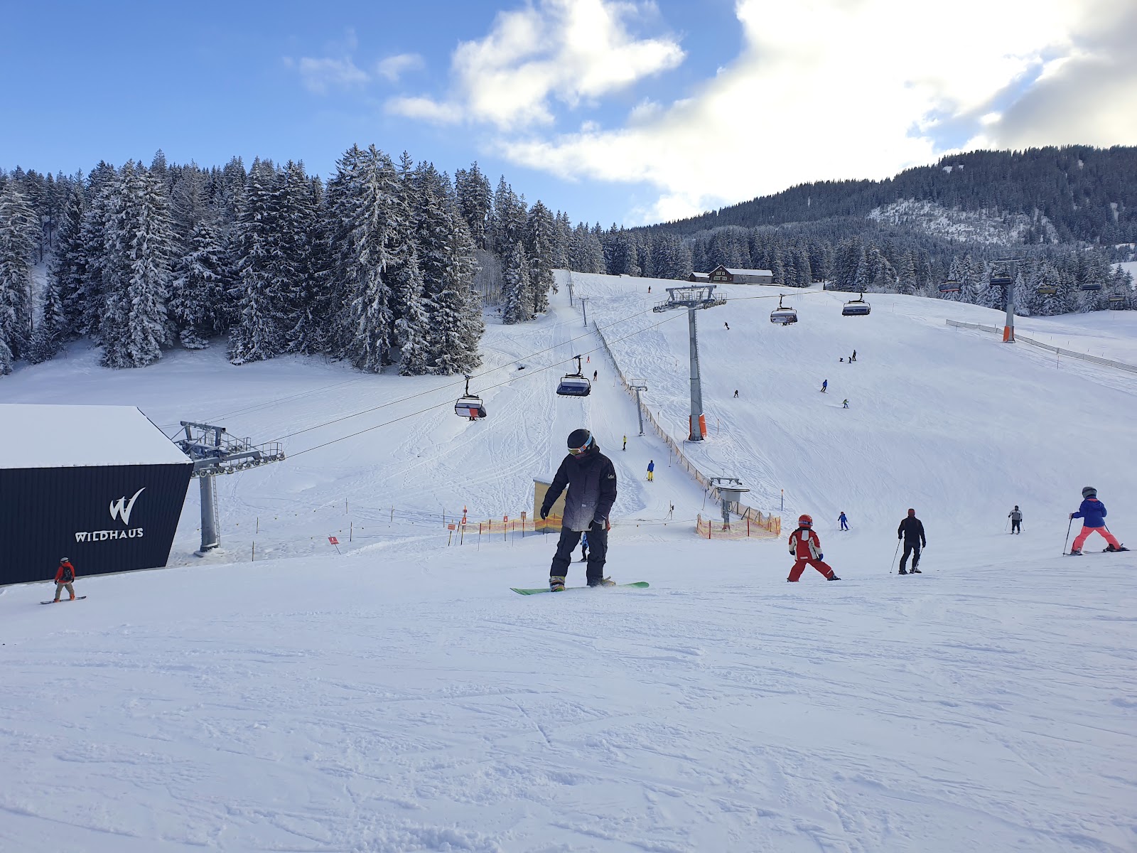 Skiers on a sunny piste in the Toggenburg ski area above Wildhaus