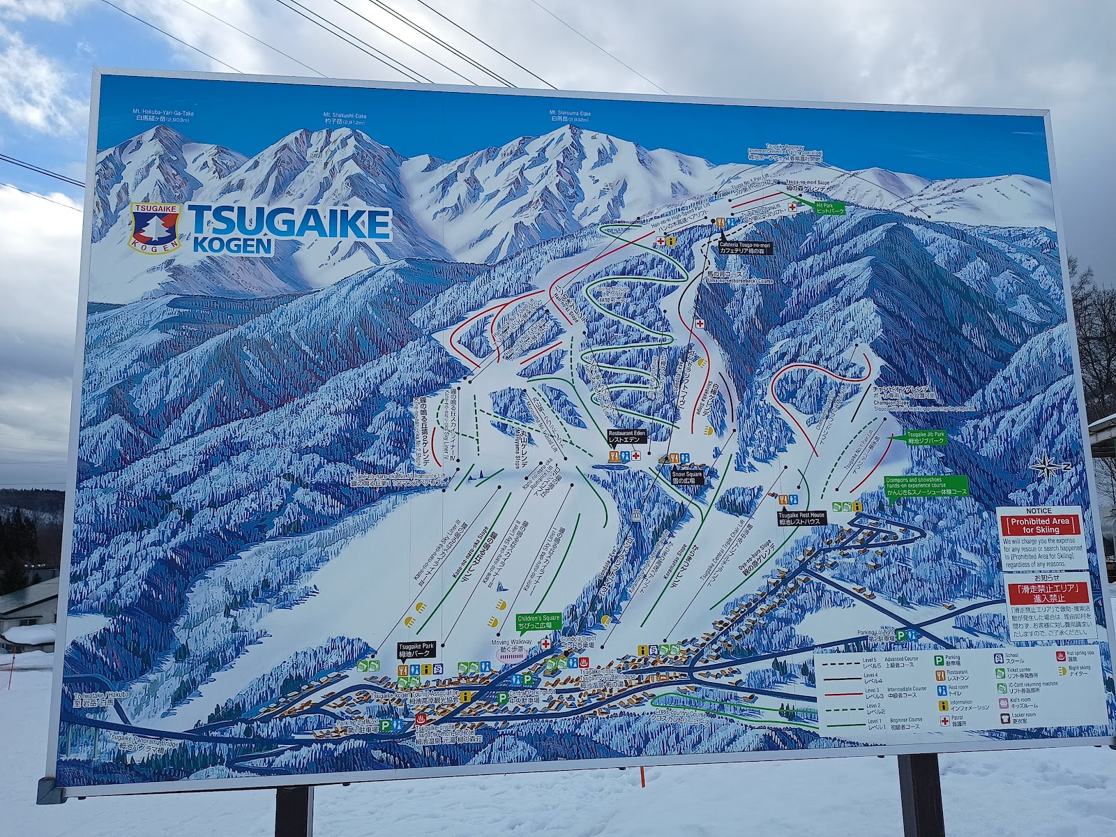 Wide snowy beginner slopes below the peaks at Tsugaike Kogen in Hakuba