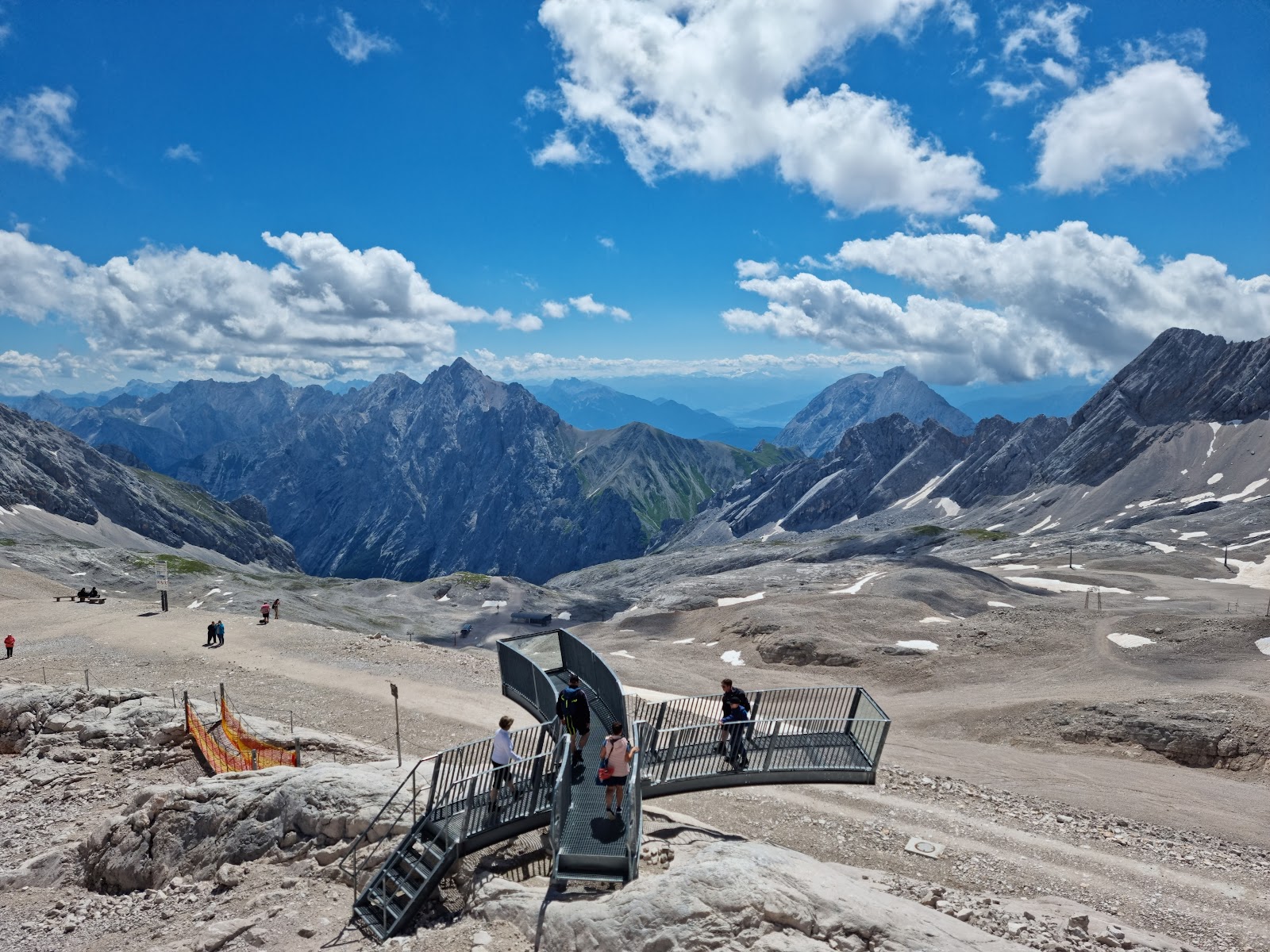 Gentle glacier pistes with skiers and a vast alpine panorama